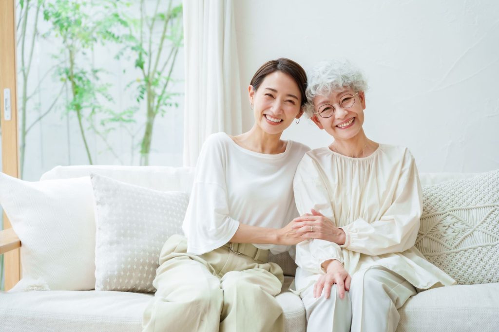 笑顔で寄り添って座る母と娘